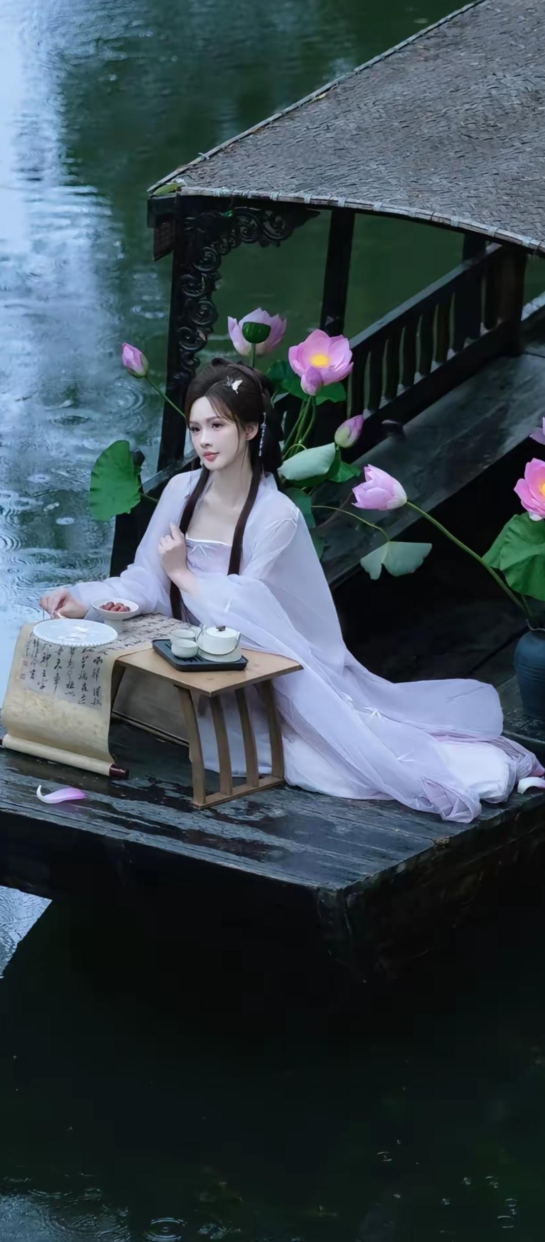 青莲居士坐船上，品茗赏花心自闲。