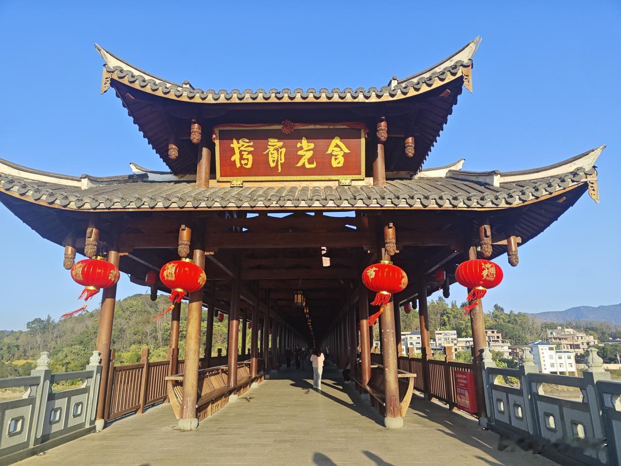 连江含光廊桥春节的骏马花灯依旧立在桥头，年味未散。古色古香的廊桥蜿蜒而过，桥下敖