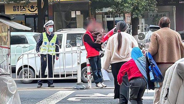 老人抱娃参与“护学岗”合适吗？

3月24日，河南省西平县柏城邵庄小学门口，马路