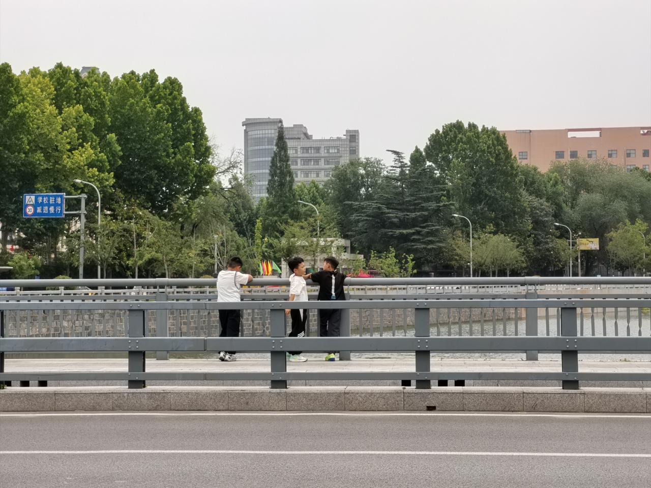 小伙伴
接二小子放学回家，在振兴北路桥上，三位小学生在一起扶栏观赏苍源河。很温馨