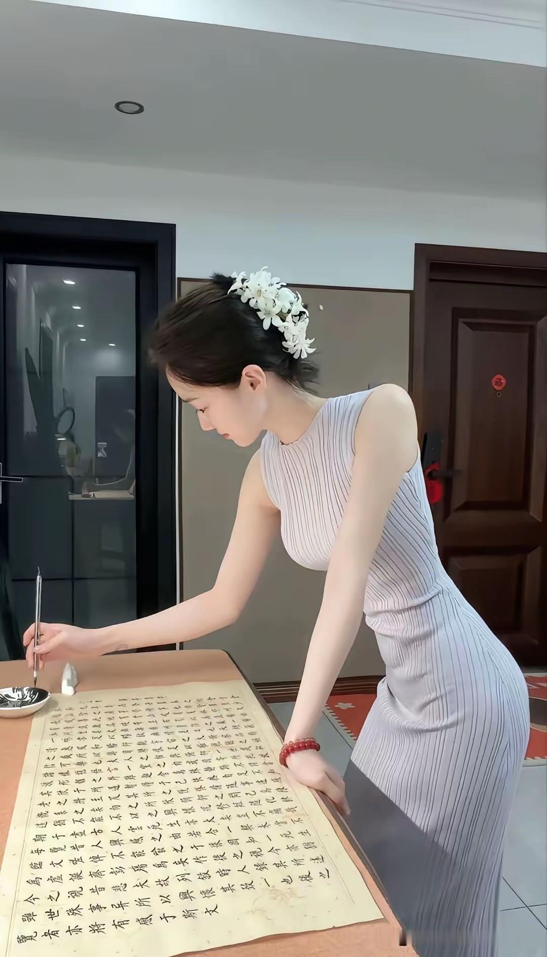 一袭浅调无袖针织长裙，简约素雅，发间点缀几朵白花，自带温婉雅致的东方氛围感。
