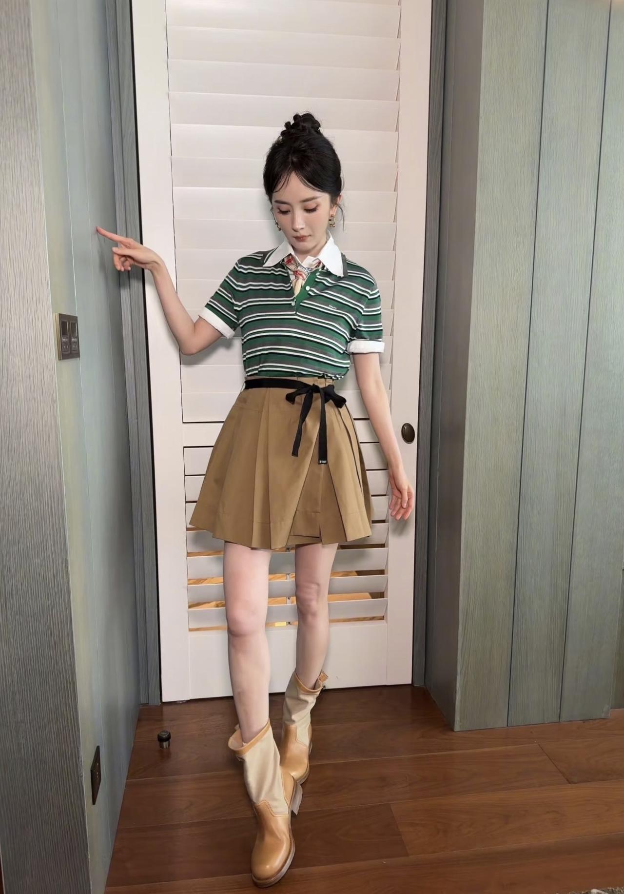 杨幂今日份造型，丸子头、条纹上衣、百褶短裙、短靴，还有少女感的气质，嘻嘻！

3