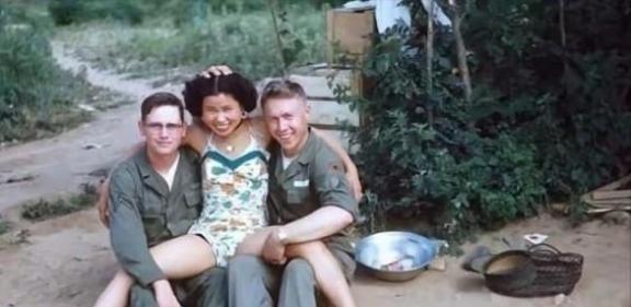 1952年，一名南朝鲜女子给两名美军做完服务后，当着老公的面热情地送大兵们离开。