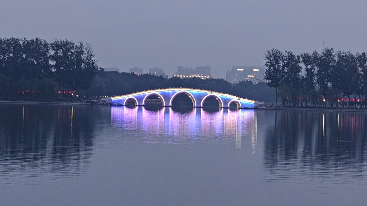 玉渊潭 
中秋傍晚，湖面波光荡漾，红灯笼随风轻摇。圆月缓缓升起，倒映水中，远处电