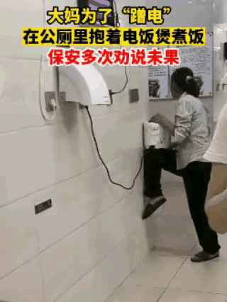 这个大妈过日子真是够抠门的了，为了煮饭省电，居然怀抱着电饭煲，在公共厕所里煮饭，