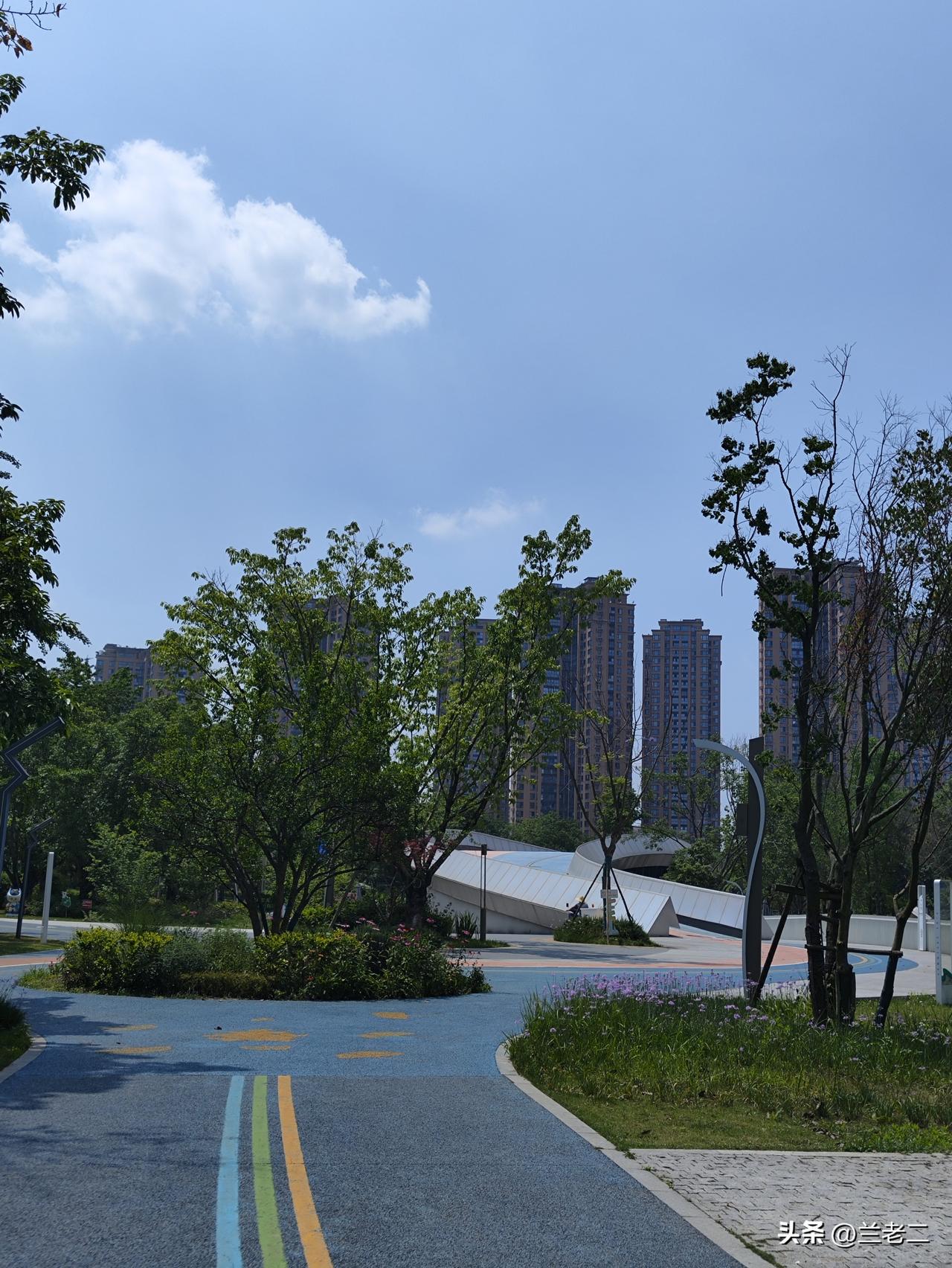 今天天气真不错，出门溜达溜达，顺便拍几张公园的风景。

蓝天干净透亮，绿树长得郁