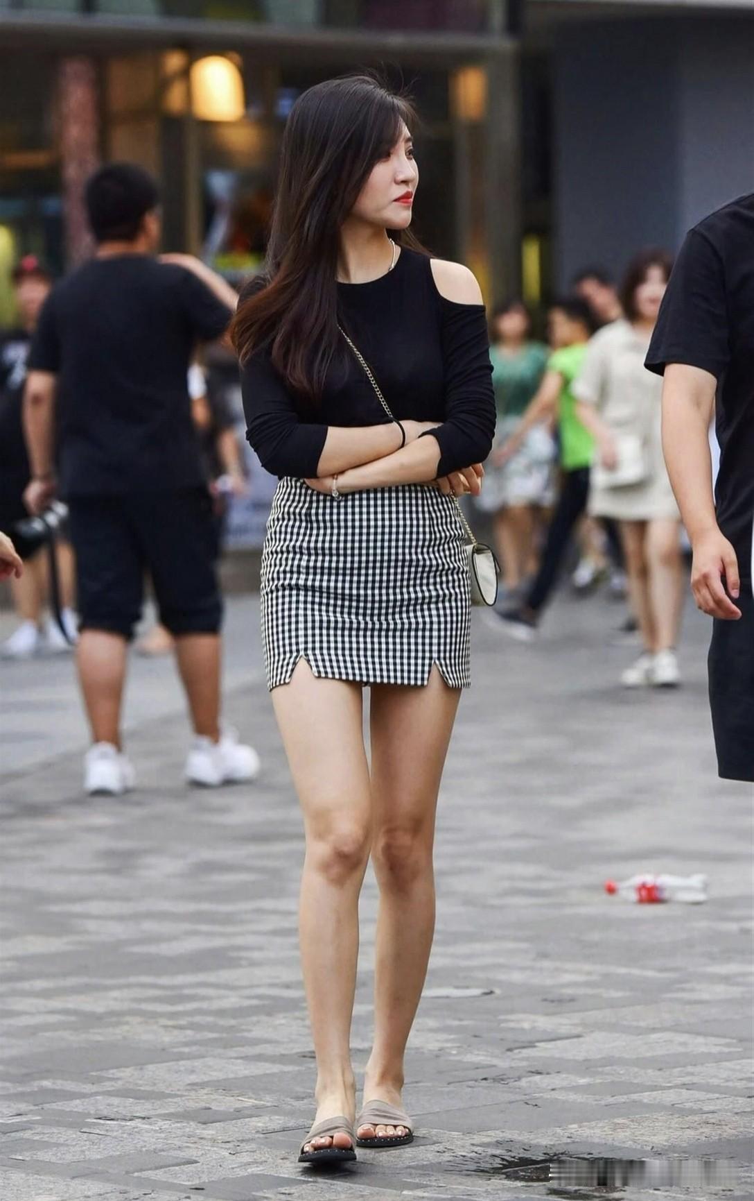 都市时尚女孩，黑白格子裙搭配黑色上衣，自信走在街头