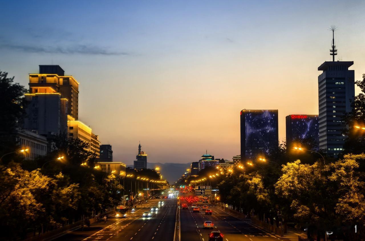 华灯初上的北京，路灯和车灯以及天边的夕阳交相辉映，构成了一幅美丽的画卷。