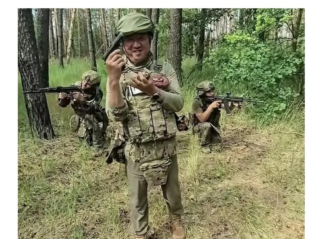 身看俄军军装，手持俄式手枪，向俄军行军礼，与俄军搜索前行，搞不明白，卢宇光是记者