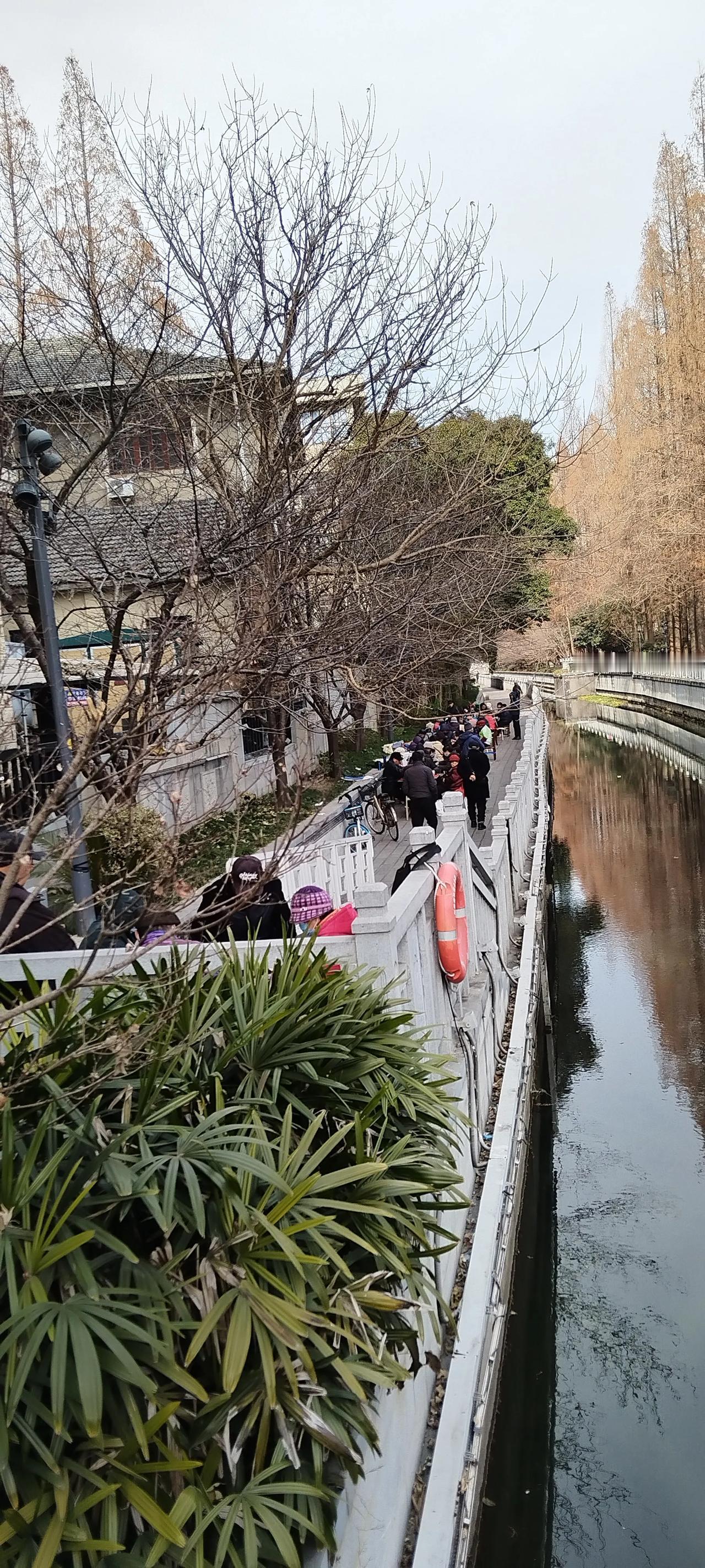 地铁浮桥站出口，大冷天的，一群老人在露天打牌！
这让我想起吉林松花江边那些不畏严