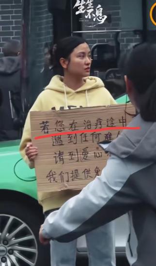 四川成都，华西医院门口有一个女孩子胸前举着一块牌子，写着提供免费住宿吃饭，很多人