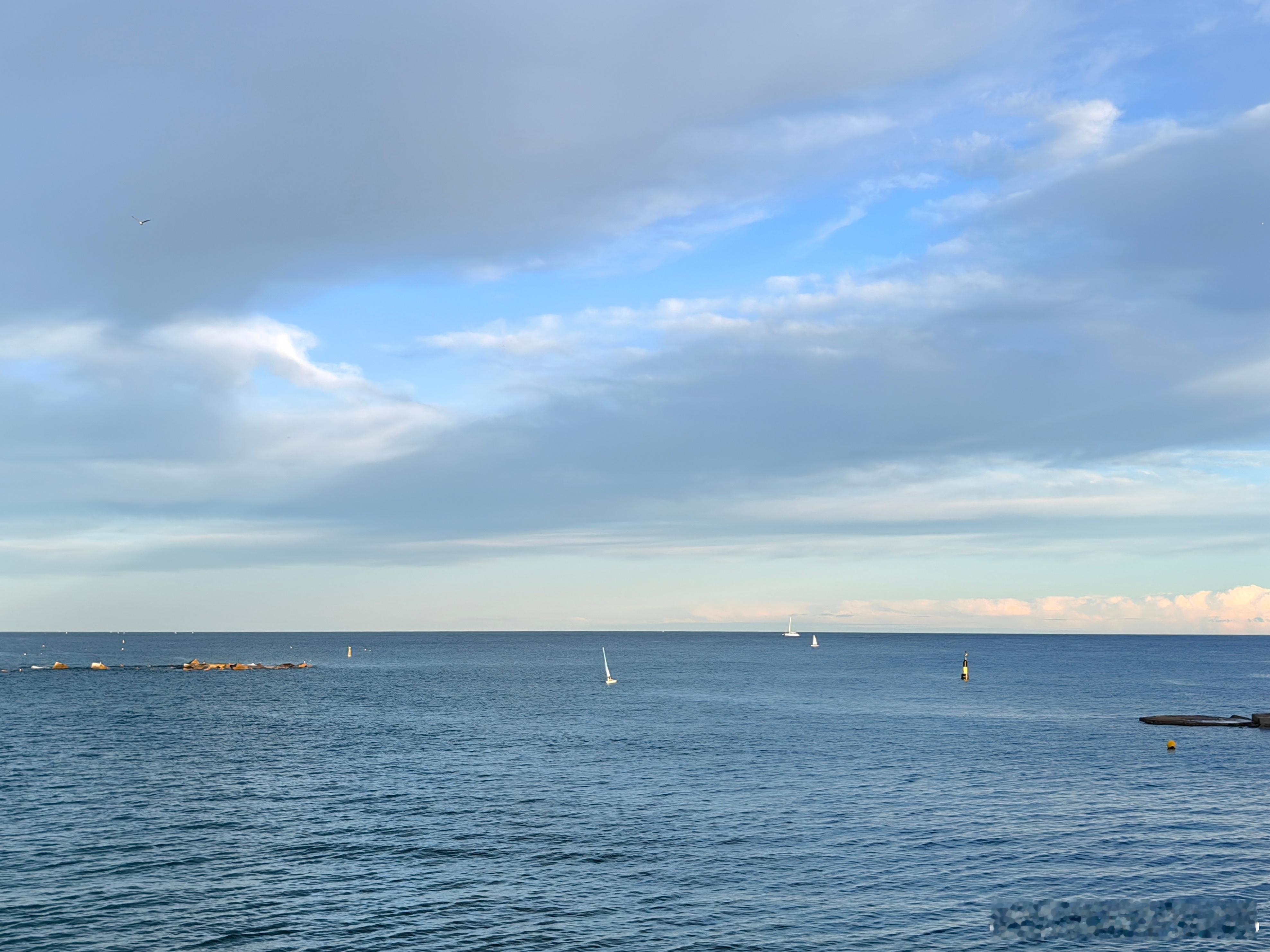 地中海的风裹着初冬的暖意，漫过巴塞罗那的沙滩。远处桅樯如林，白艇轻晃，连云都慢成