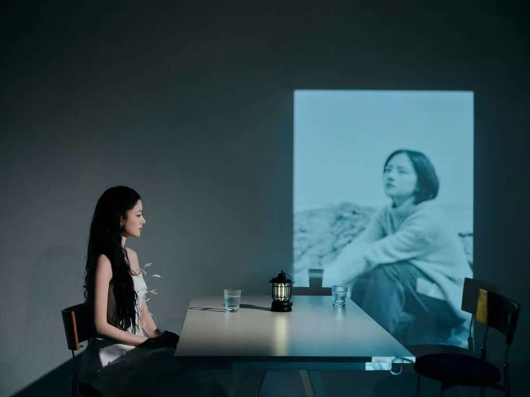 任敏隔空为易遥擦眼泪白裙的任敏抬手触碰投影里哭泣的易遥，像触碰曾经的自己。这一幕