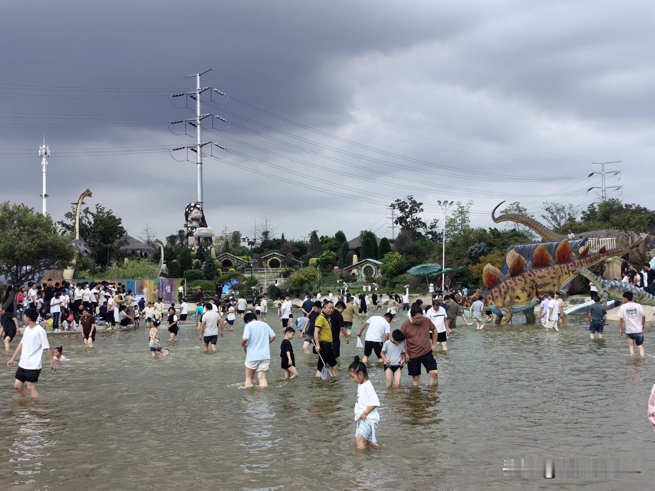啊呀！真是太搞笑了！一群人在水中向前走去！要去干嘛呢？！

原来是要去摸鱼。这是