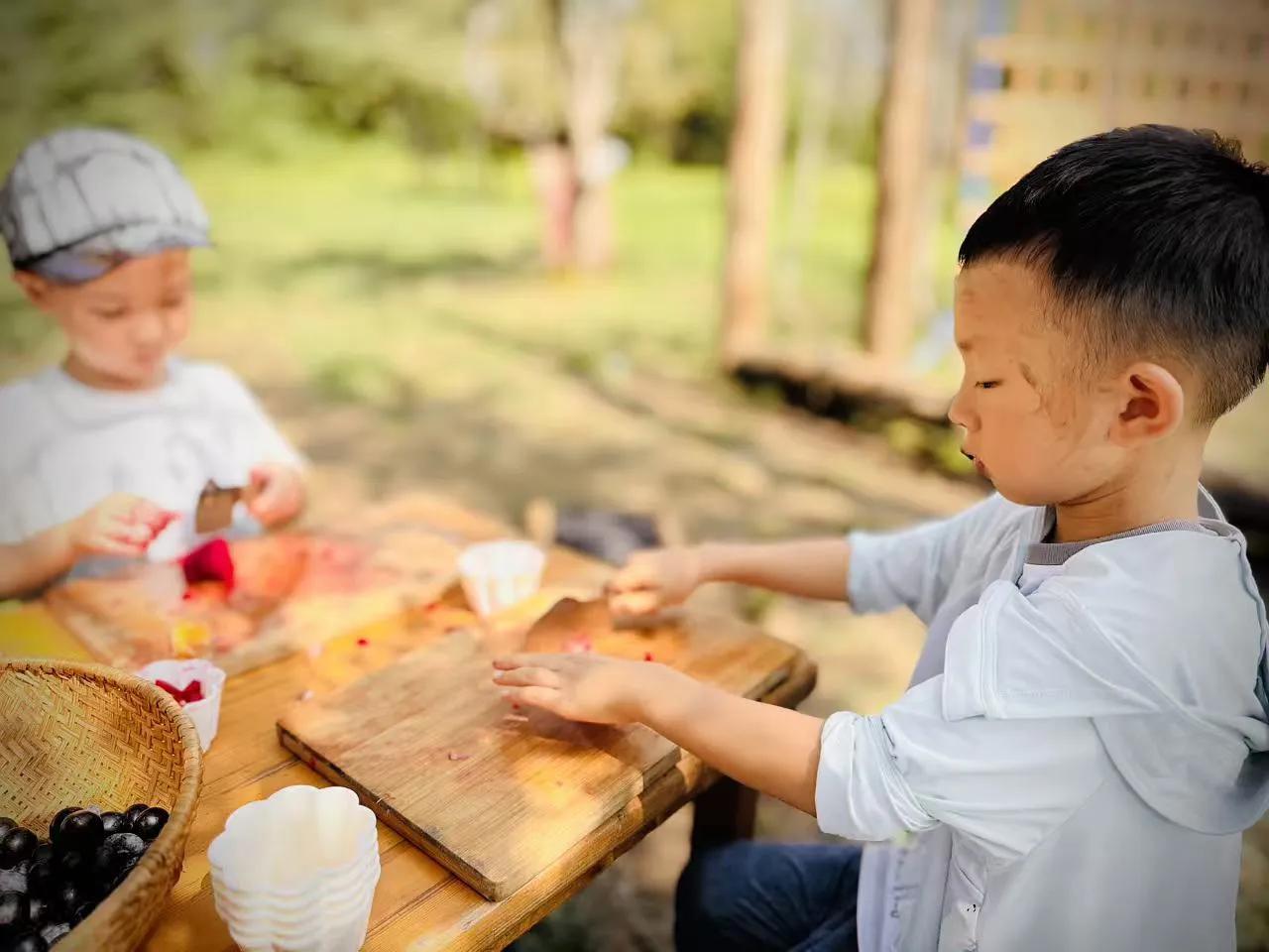 幼儿园里开展手作生日蛋糕活动，小朋友们满怀期待围坐在桌前。大家小心翼翼涂抹奶油，