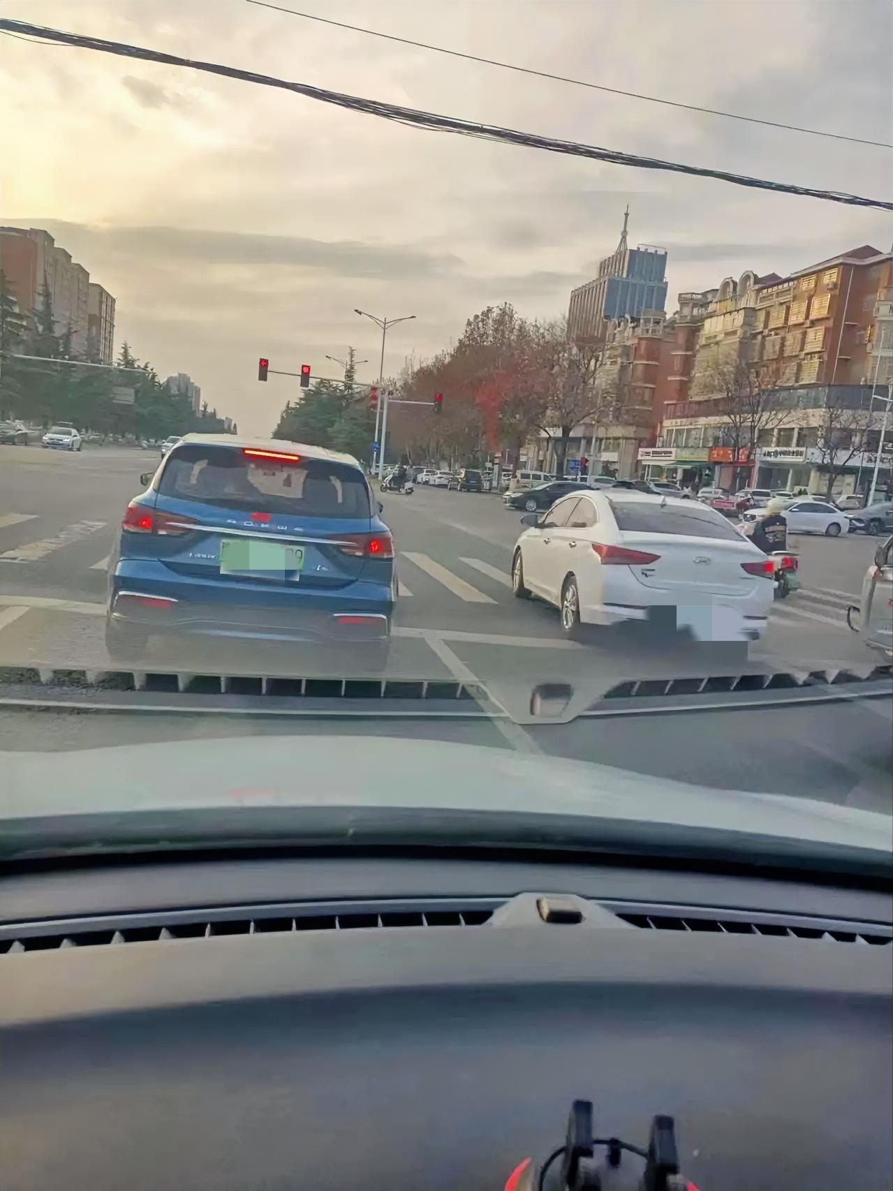 等红灯的瞬间
 
停在路口等红灯，车窗摇下，风裹着初冬的凉意漫进来。视线里是缓行