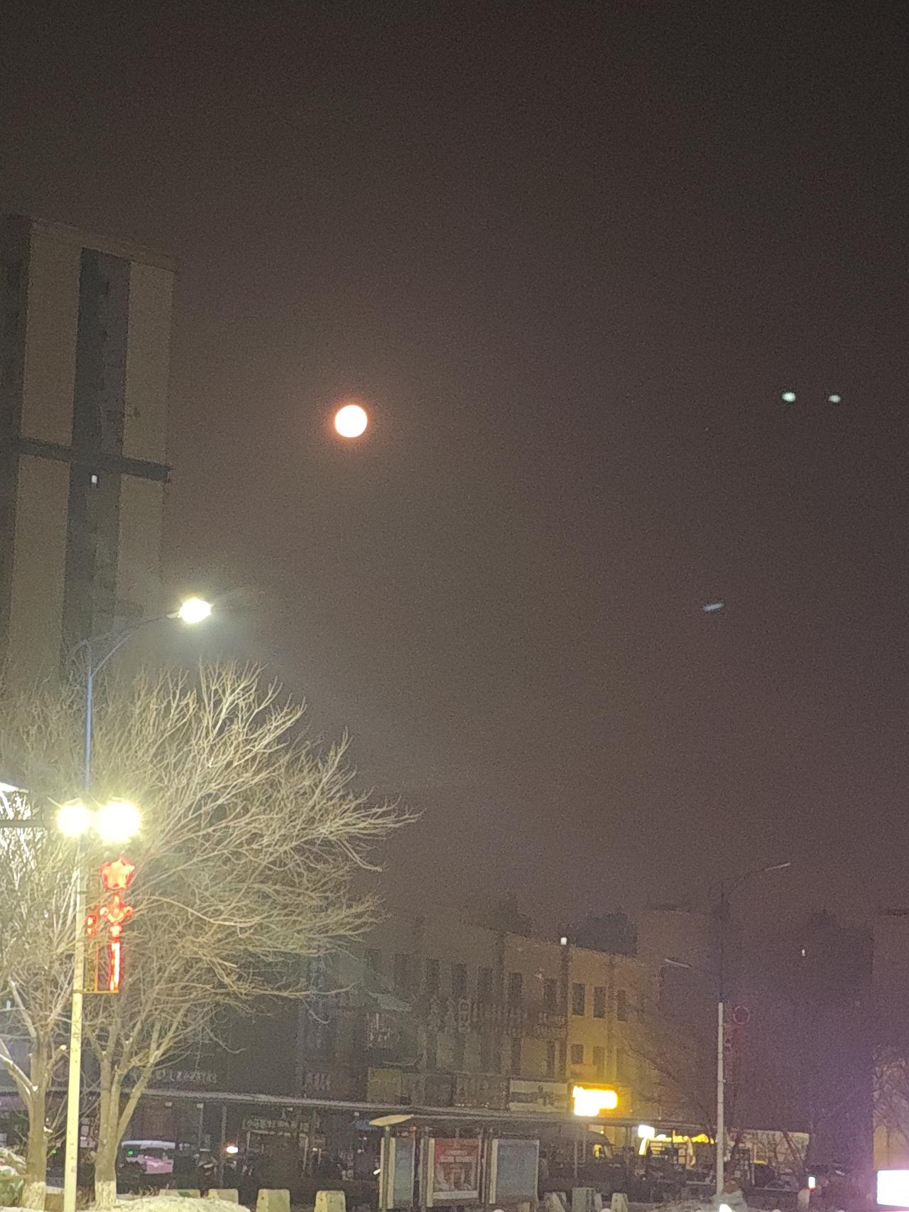 疆西月
将晨，轮月西挂，藏于楼宇之间，千里白雪茫茫，尽被朦胧掩盖。天山滑冰，与山