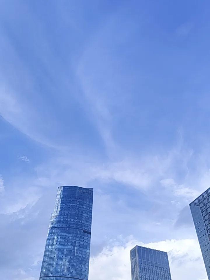 昆明的蓝天白云，真是美极了，你看看那个高楼耸立在白云蓝天之间，很漂亮啊