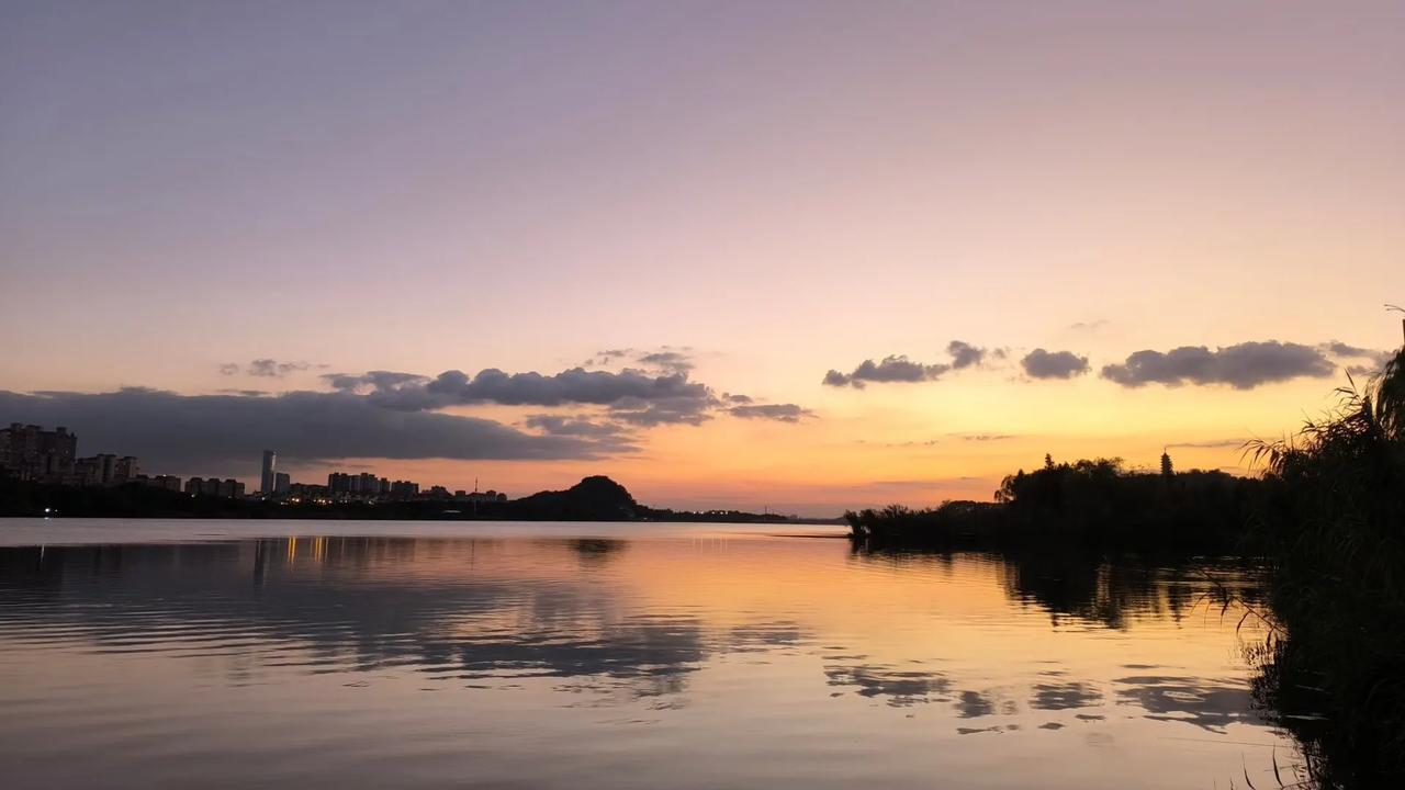 秋日金山湖，夕阳映波澜。
层云似彩绸，轻纱绕岸边。
湖面金光闪，渔舟逐浪闲。
远