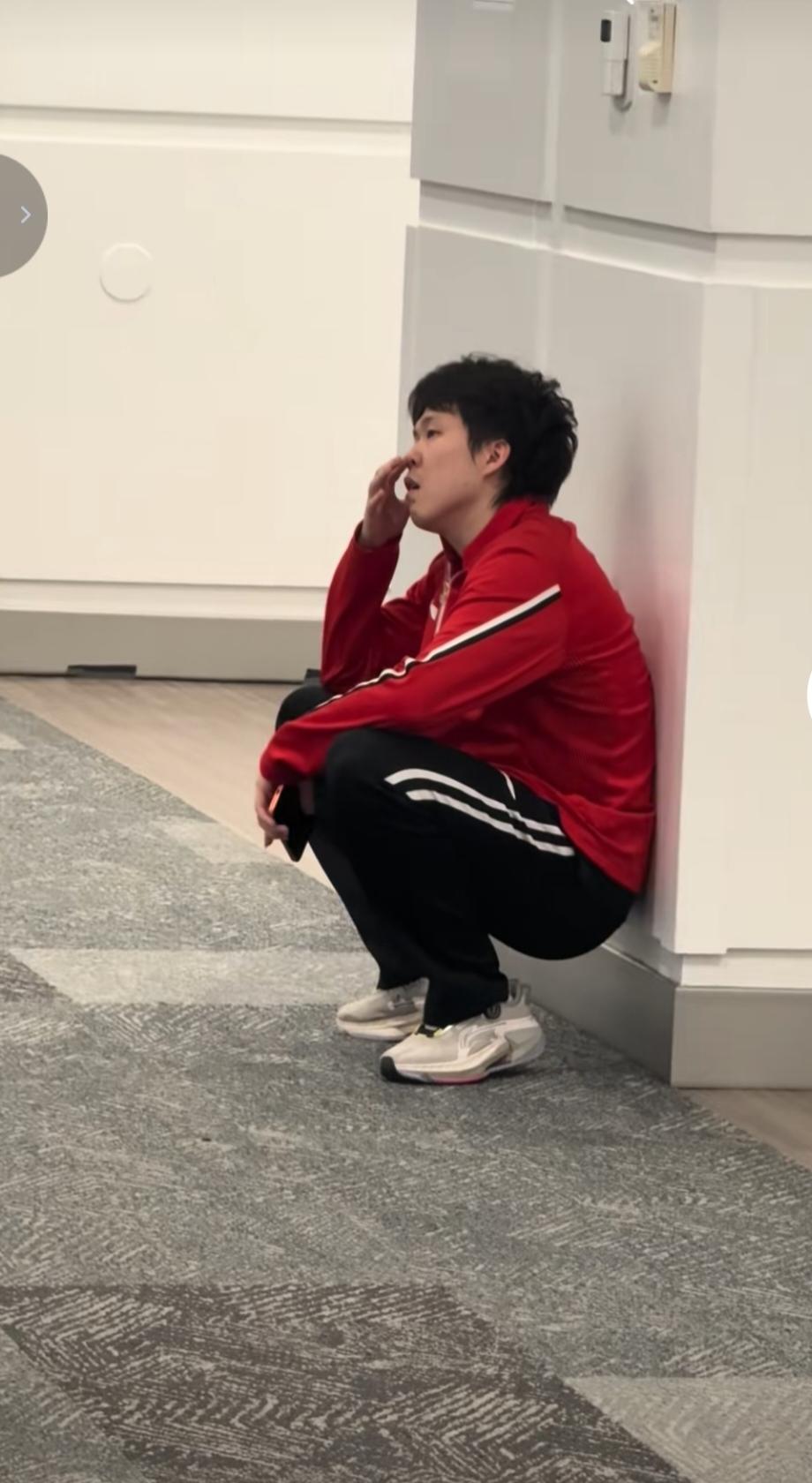 王楚钦输掉比赛蹲在墙边，情绪有些低落，似乎在想着自己为什么会输得那么惨。他的实力