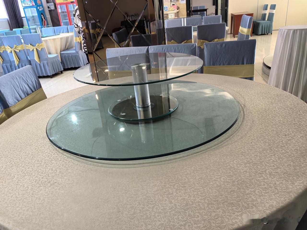 京山市的一些中小餐厅，比较普遍使用带有高低、大小、转速快慢不同的玻璃转盘的餐桌。