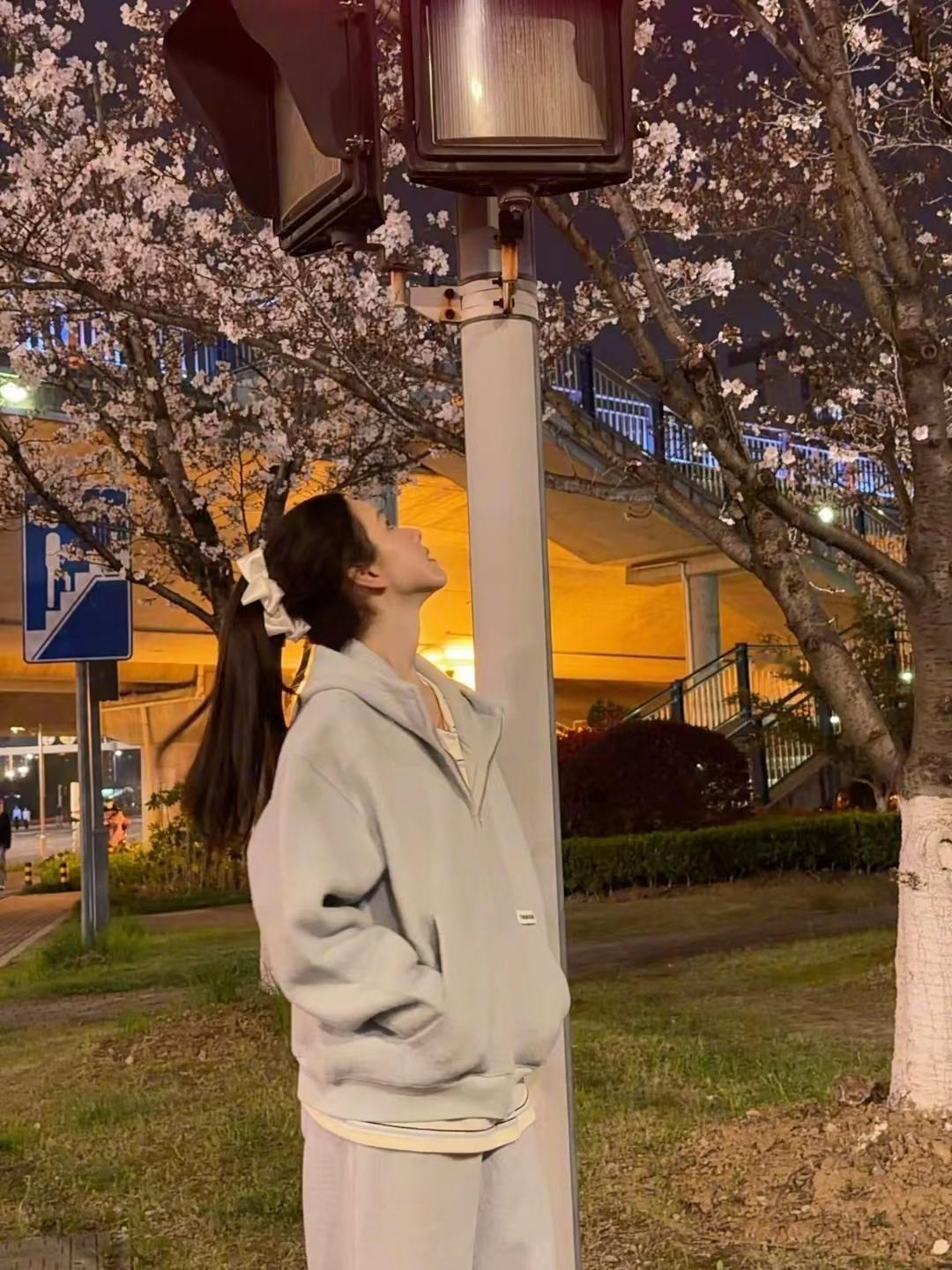 陈都灵下班偶遇春天的花  陈都灵下班偶遇春天的花  灰色卫衣高马尾造型俏皮可爱，