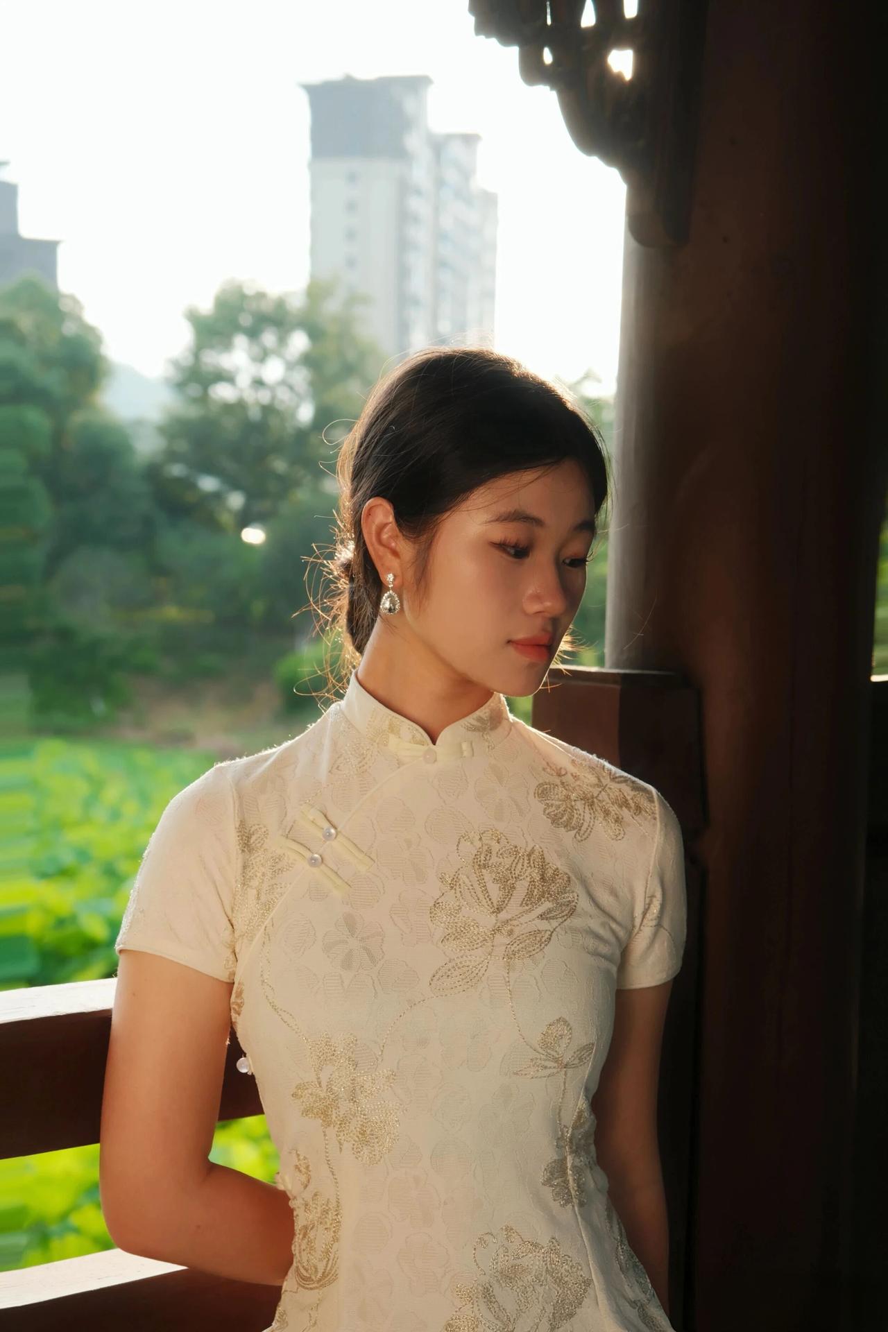 那旗袍上金线绣出的花枝，不是静物，而是活生生的春意——每一片叶脉都似在呼吸，每一