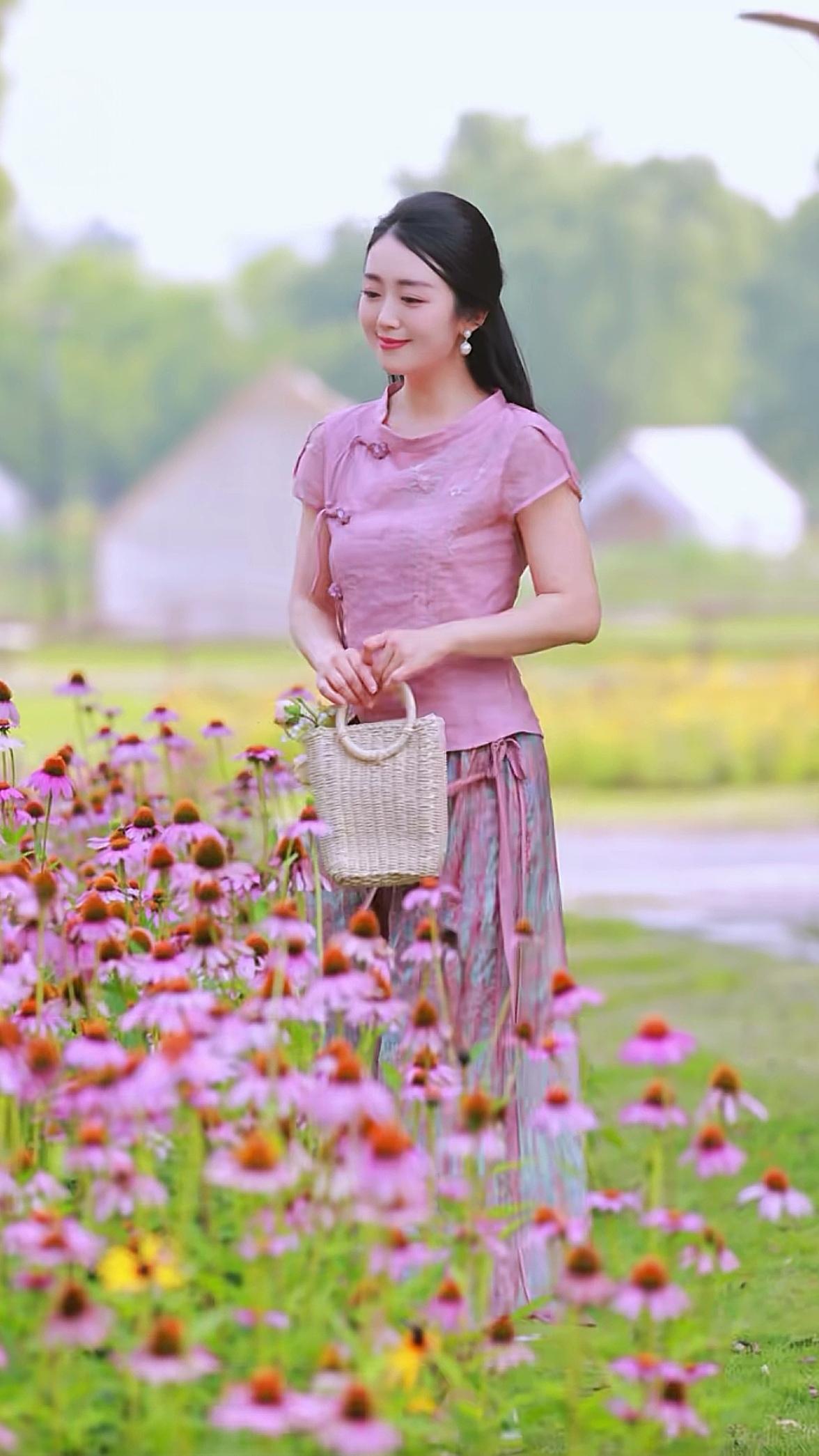 想象一下，一位身着粉嫩古风服饰的少女，悠然漫步于粉黛乱子草的花海之中，那画面别提