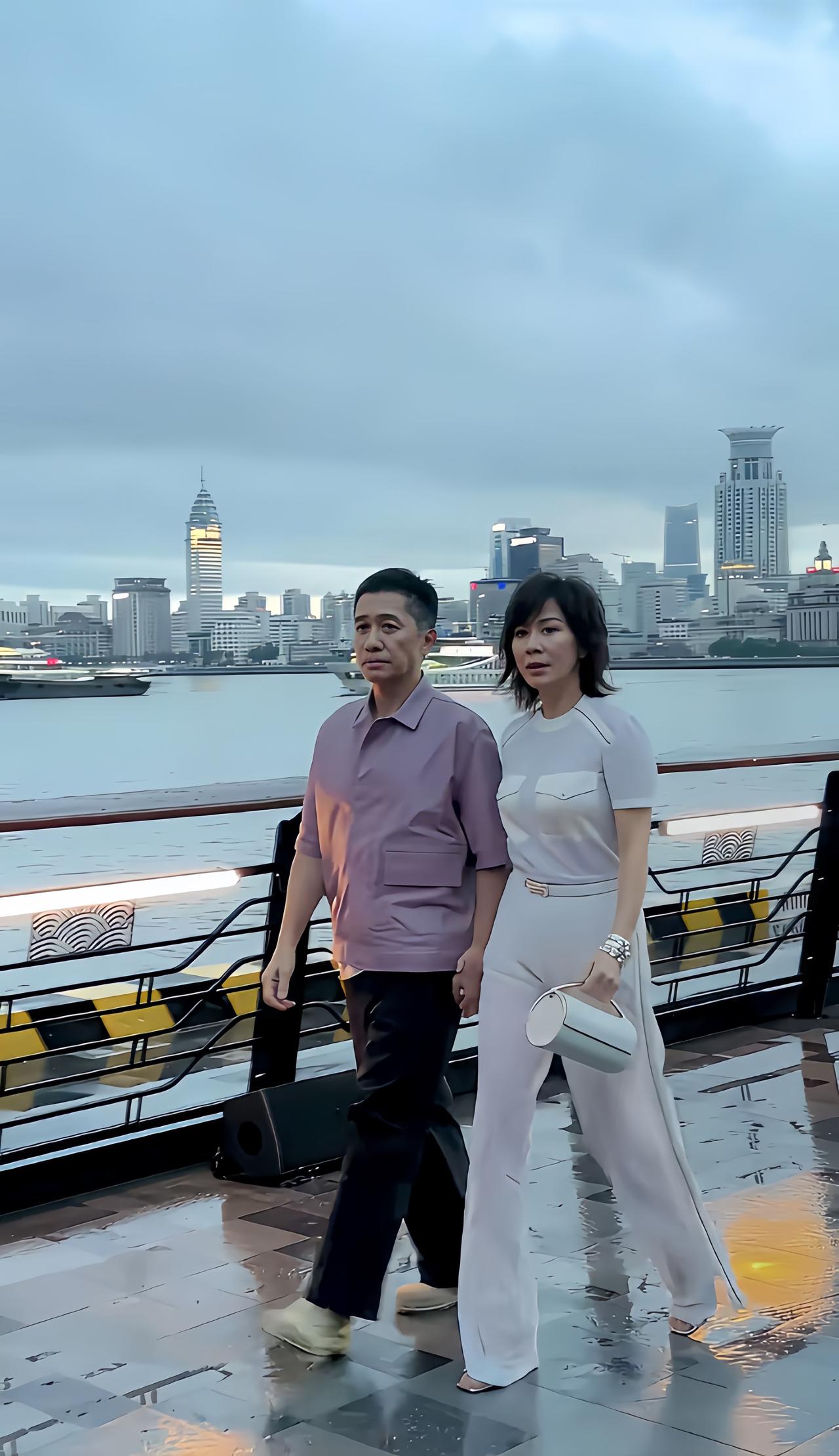 近日，梁朝伟、刘嘉玲夫妇现身上海，在傍晚江边散步的画面。

看似是梁朝伟牵着刘嘉