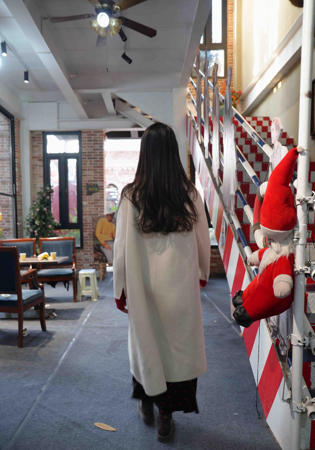 冬日暖阳下的咖啡馆，圣诞老人玩偶陪伴，温馨氛围满满。