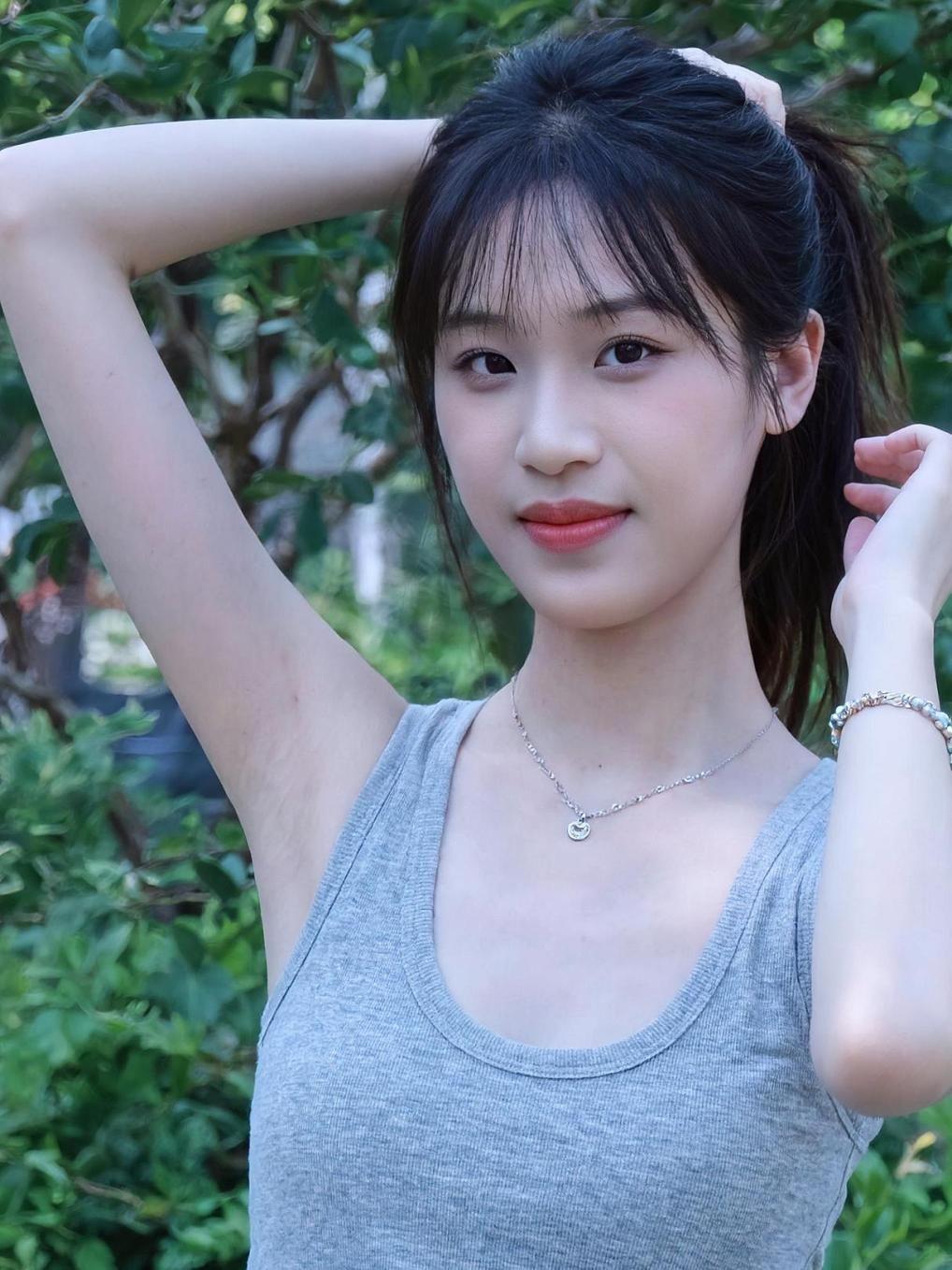 在夏日的午后，阳光透过树叶的缝隙，洒在她的发梢上，仿佛为她镀上了一层金色的光晕。