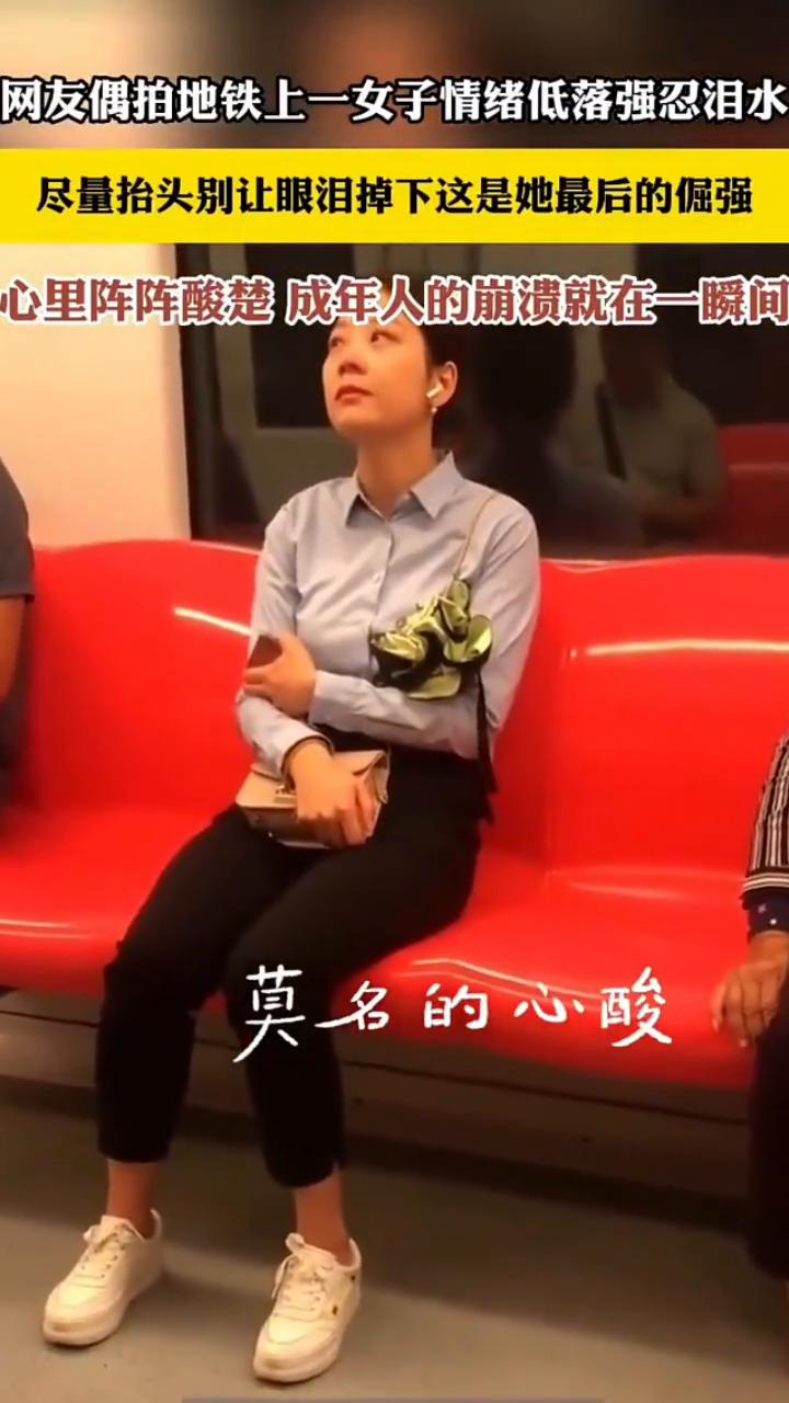 网友偶拍地铁上一女子情绪低落强忍泪水，尽量抬头别让眼泪掉下，这是她最后的倔强。
