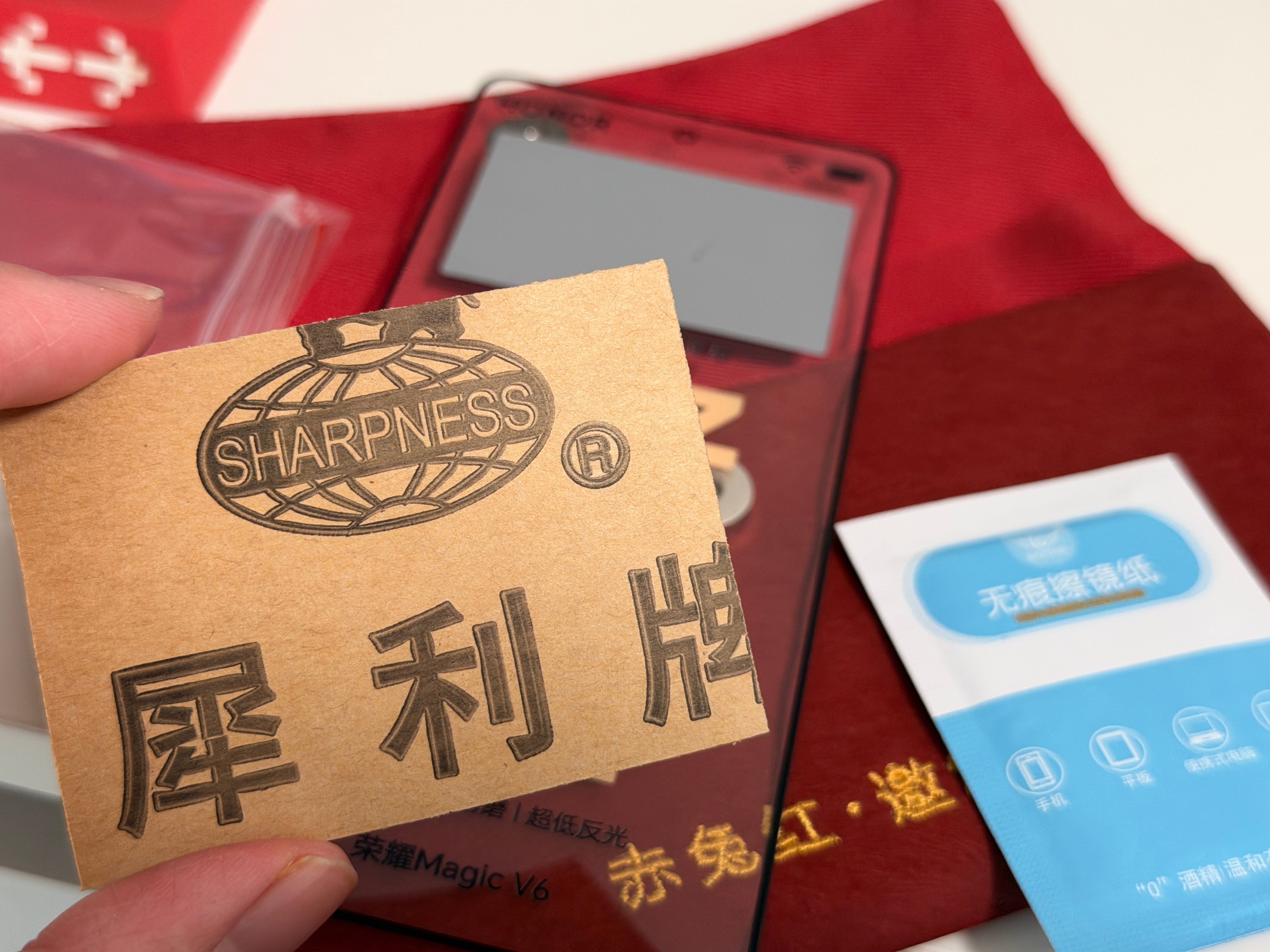 收到荣耀Magic V6邀请函是一块屏幕，还带了块砂纸至臻黑钻屏，抗摔抗刮抗磨超