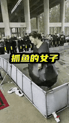 女子在商场里参加抓鱼比赛，水池围子里的鱼可以随便用一抓，但是不能够用袋子或者用桶