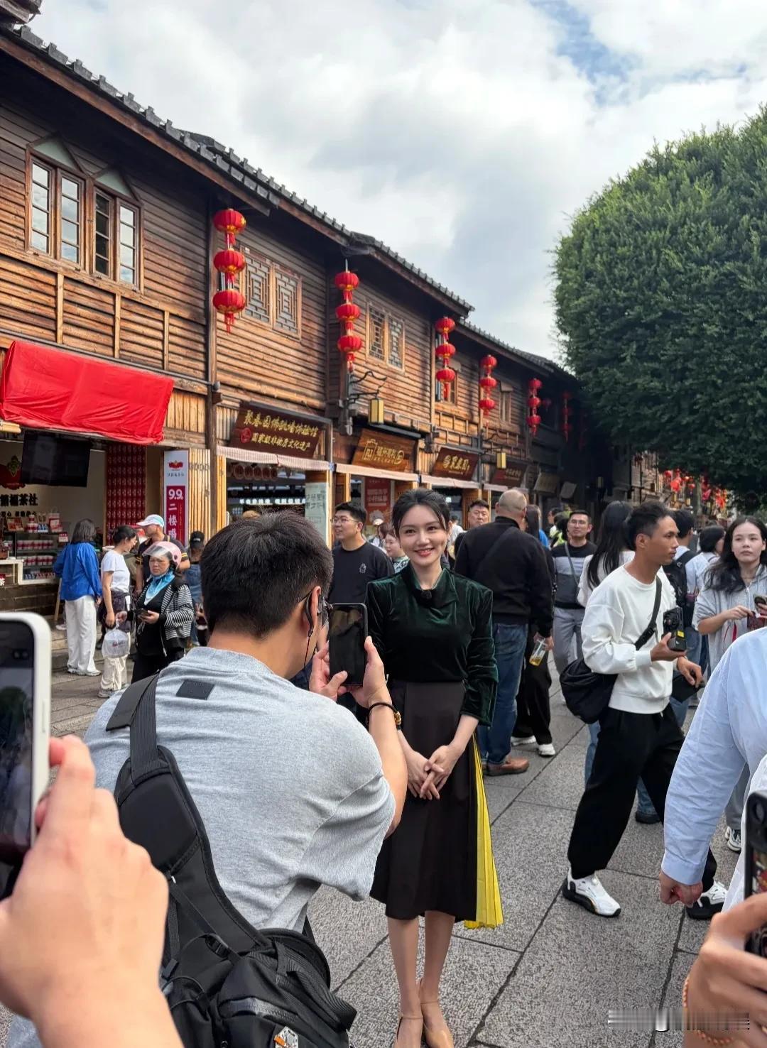 央视当家主持人龙洋现身福州三七坊，穿着绿色缎面长袖配半身裙，长眉凤目，鼻子高挺，