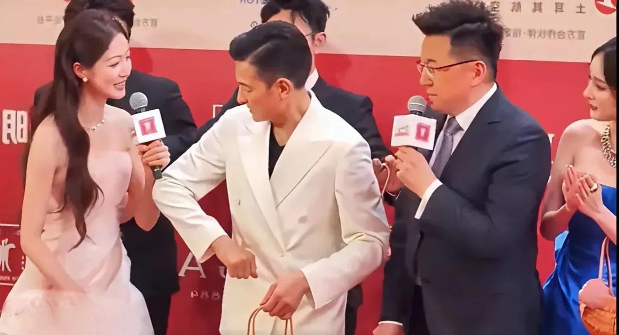 刘德华弯起了胳膊，是等着女主指人来挽的吧，可主持人无动于衷，竟然不挽天王的胳膊，