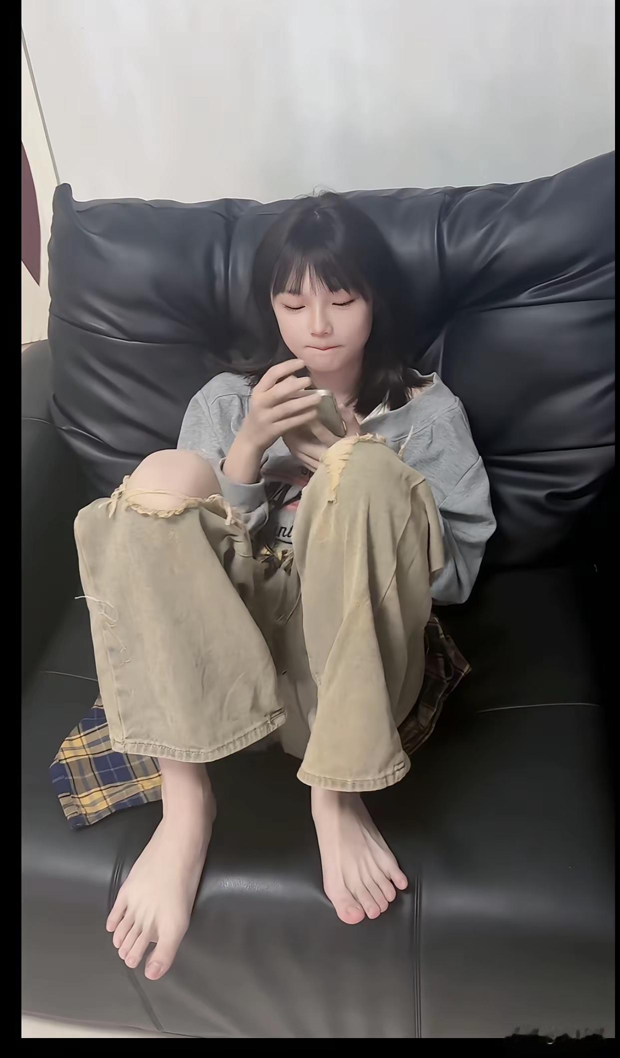 一个人坐在沙发上玩手机。 躺卧玩手机 玩手机好专心 久躺刷手机
