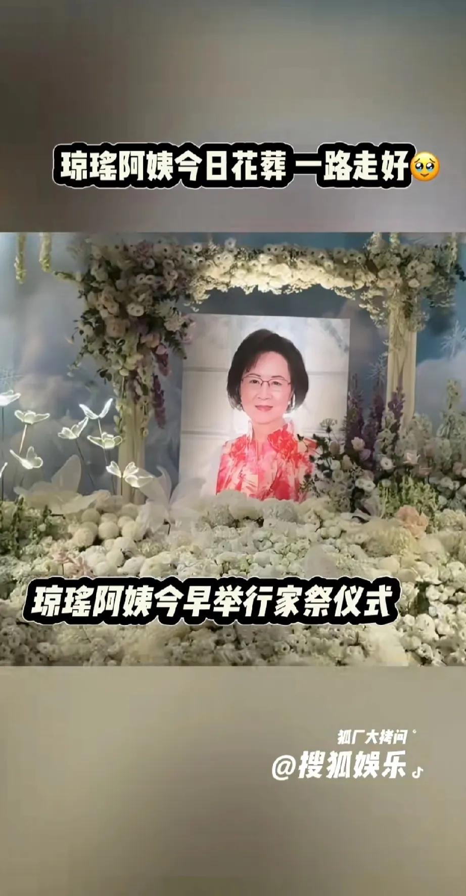 琼瑶阿姨的花葬仪式，
照片周围铺满了鲜花，
被黑伞遮住的是谁呢？