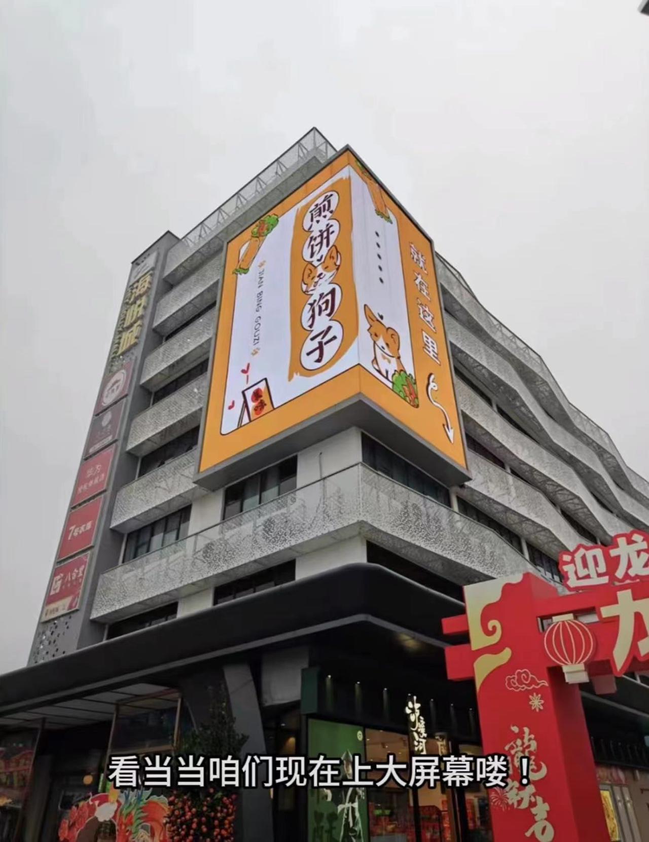 狗头萝莉卖煎饼出息了，广告打了一整栋楼
前一阵子狗头萝莉因为生病的缘故，煎饼摊子