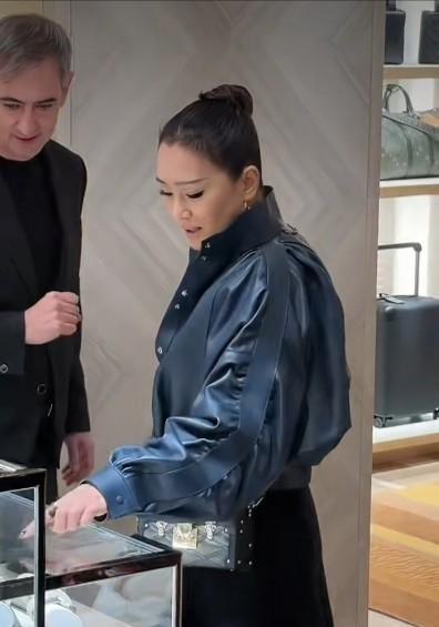 巩俐的丸子头里，藏着一盘好莱坞大棋。
深蓝高领裹住脖颈，黑色短裙下紧身裤勒出线条