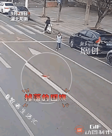 湖北，一个小女孩放学过马路回家时，发现路中间有一面国旗，她毫不犹豫，不顾个人安危
