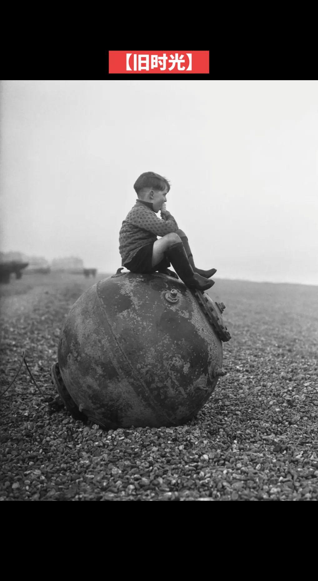 【旧时光】1940年2月，英国肯特郡迪尔，一个男孩坐在被冲上岸的水雷上享用冰淇淋