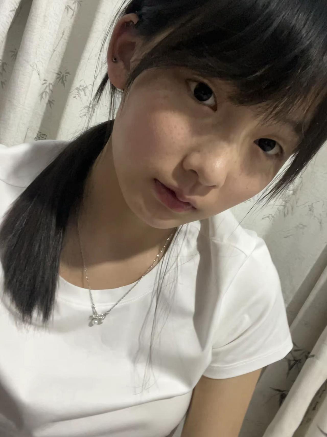 这姑娘扎着马尾，看着镜头。