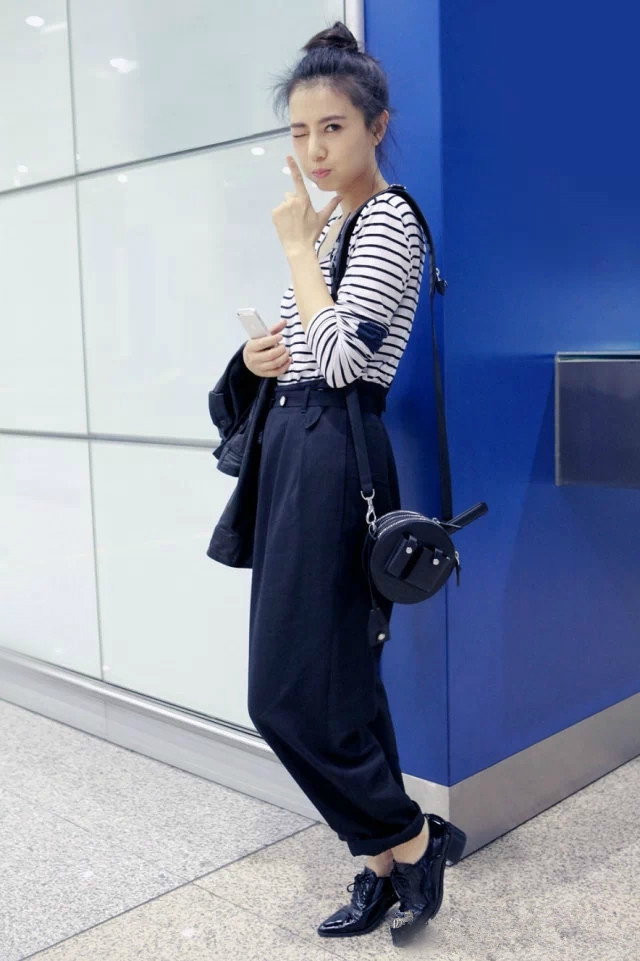 看姐姐这组机场街拍直接被戳中！丸子头配条纹衫，随性又灵动，对着镜头wink搞怪的