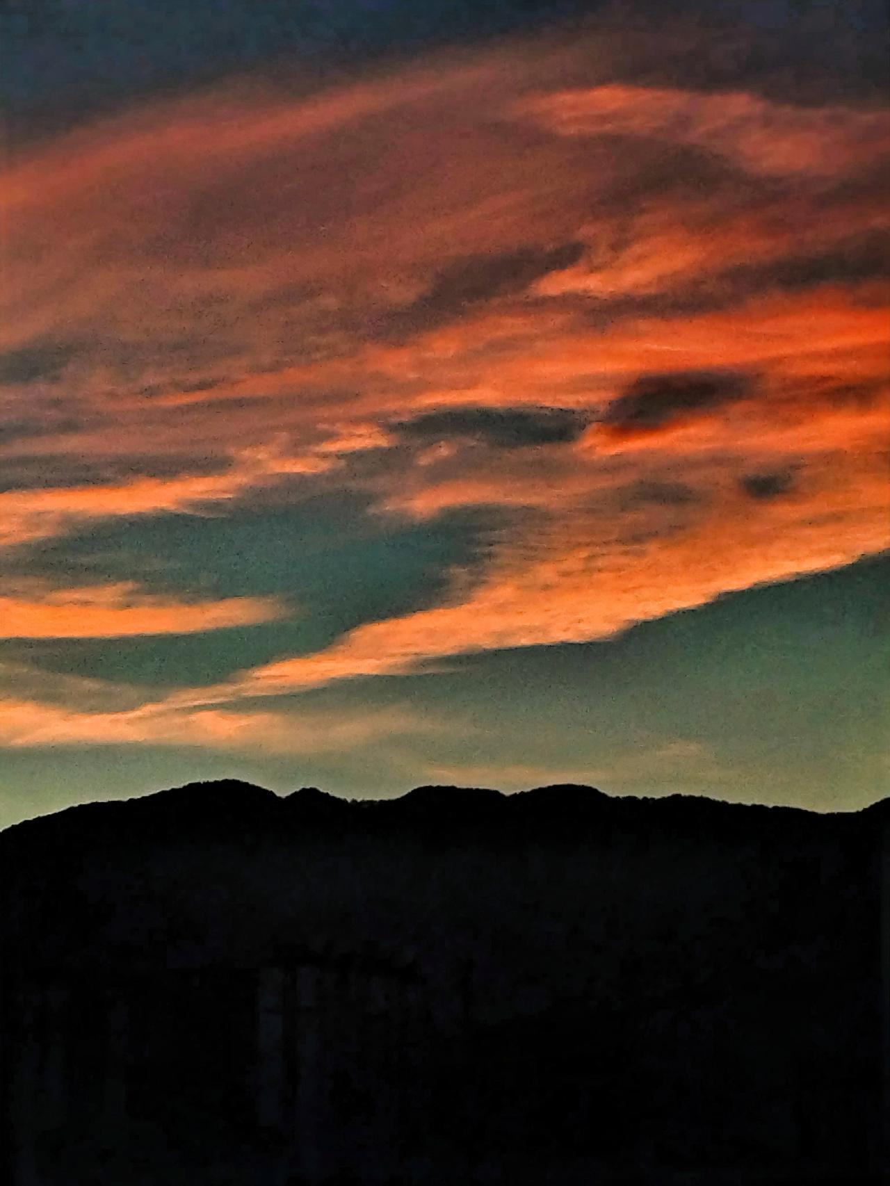 夕阳西下，云海翻滚，静谧山峦映入眼帘。这般美景，恰似大自然用心勾勒的画卷。夕阳如