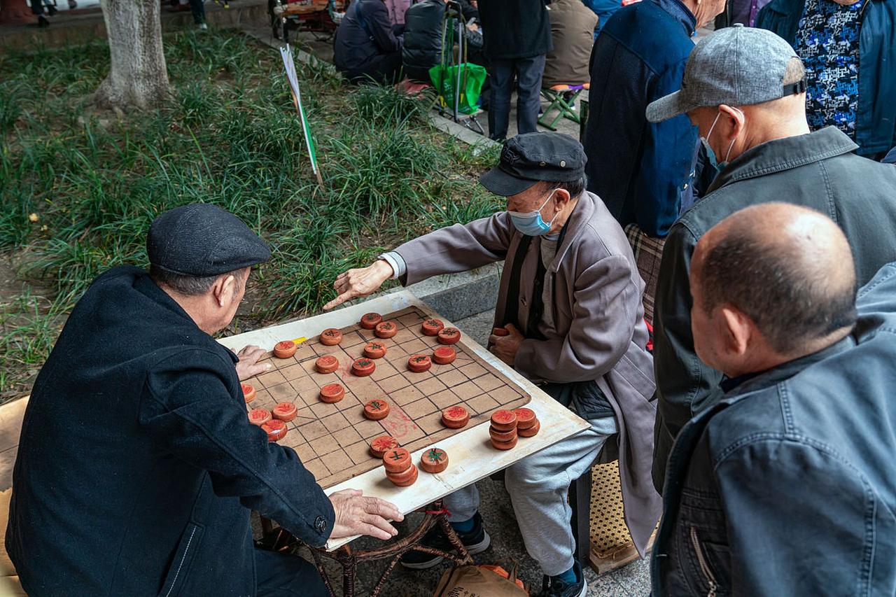 绿化带里的跨国棋局
晨跑总见退休张伯对着绿化带比划，直到某天发现他在用树枝摆残局