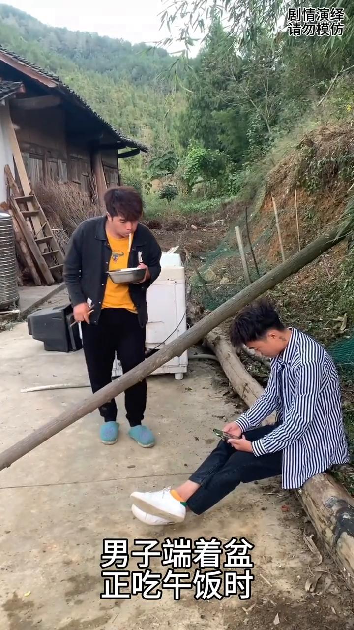 男子端着面条准备越过木头找朋友时，下一秒剧情大反转。
男子端着盆正吃午饭时，这时