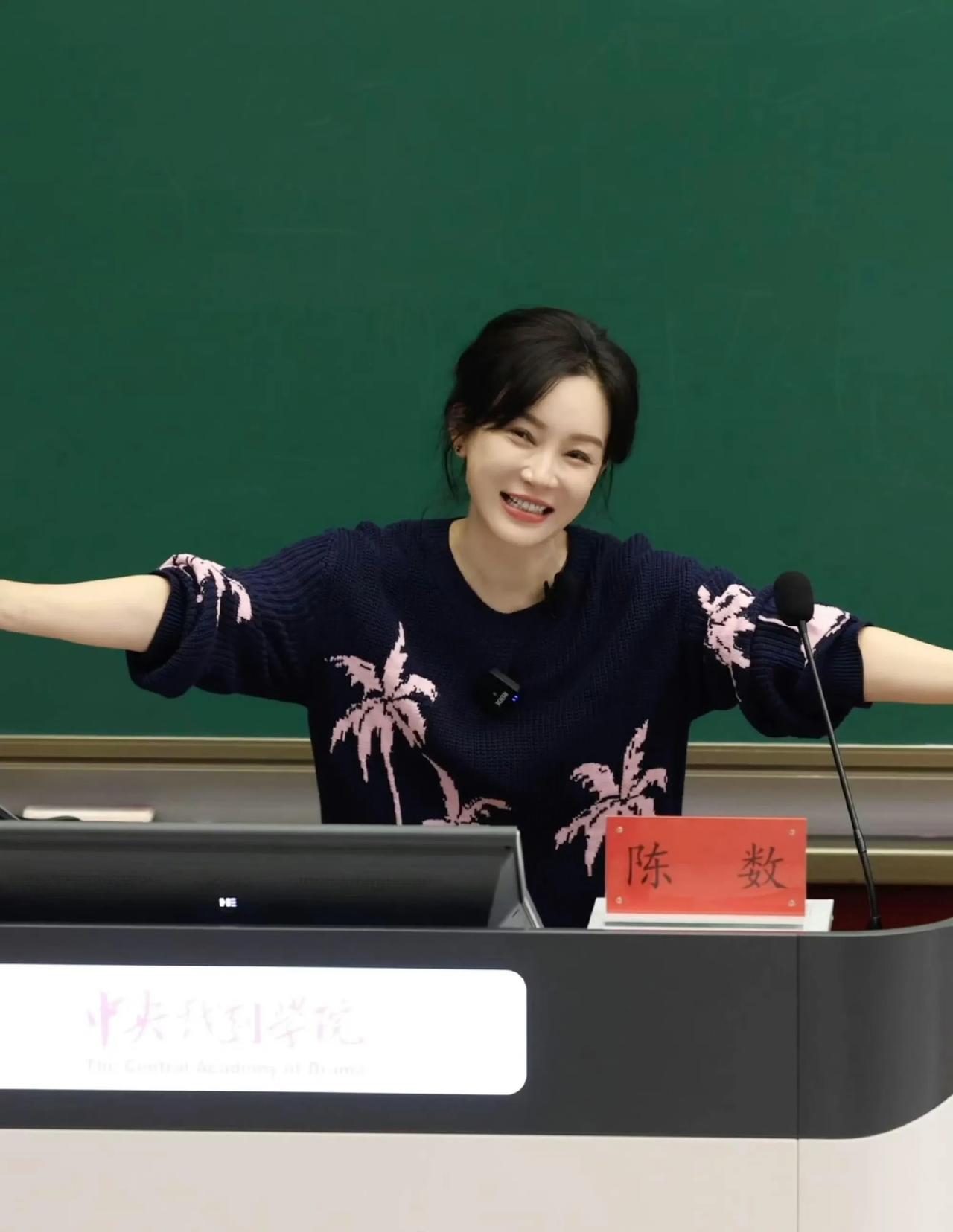 在讲台上演奖的她谈笑风生，就像读书时候见到的老师一样和蔼可亲！她张开双臂，满脸如