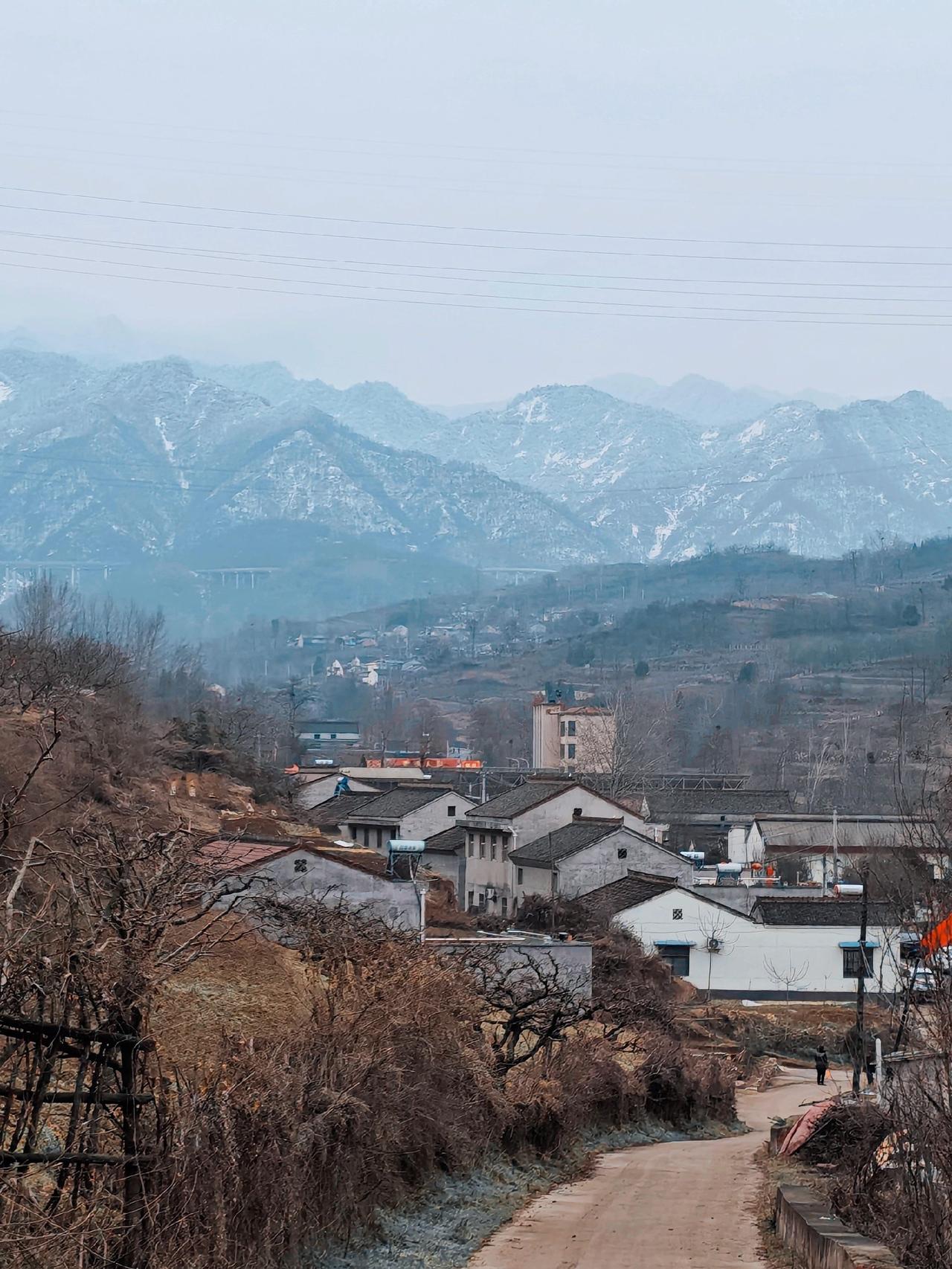 远处的秦岭雪与近处的村庄，横亘在山间的是宝汉高速秦岭雪景 抖出你的家乡