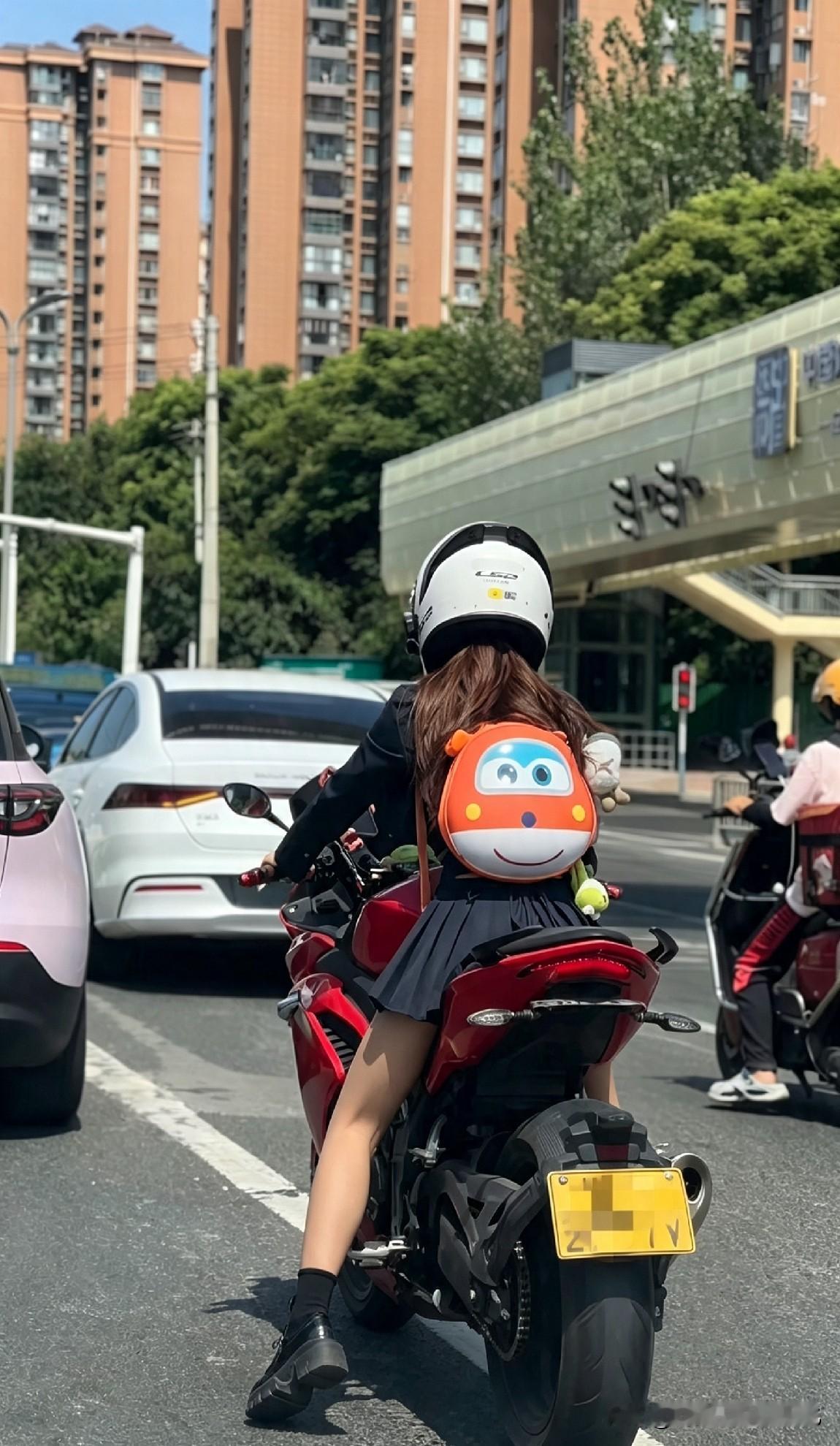 骑红摩托背乐迪书包的姑娘，被路人“搭讪”后一句话让全场笑喷

她停在路口。

红